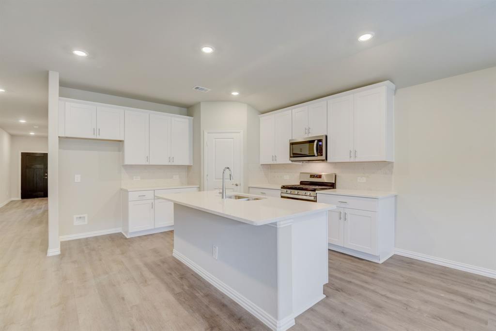 a kitchen with stainless steel appliances a sink stove and refrigerator