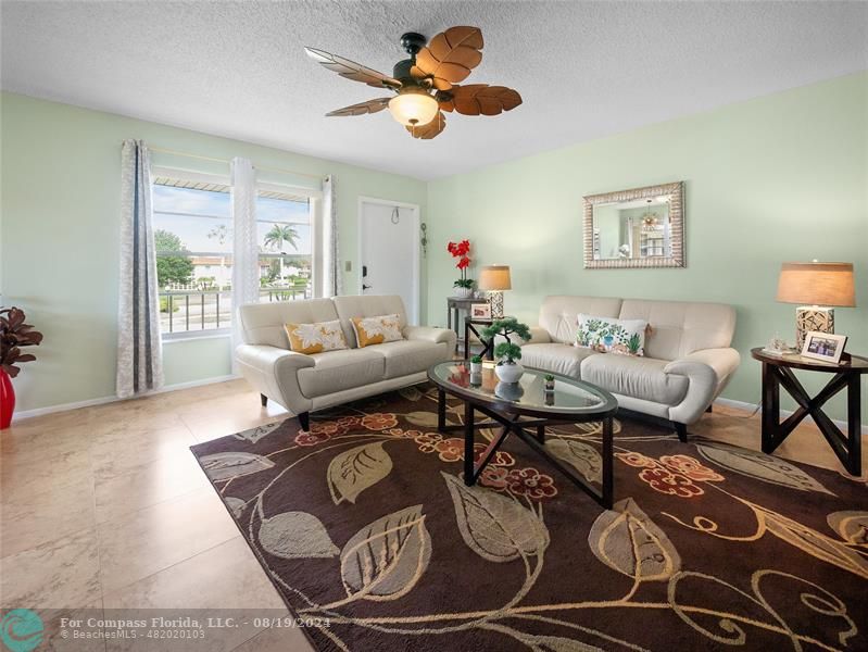 a living room with furniture a chandelier and a rug