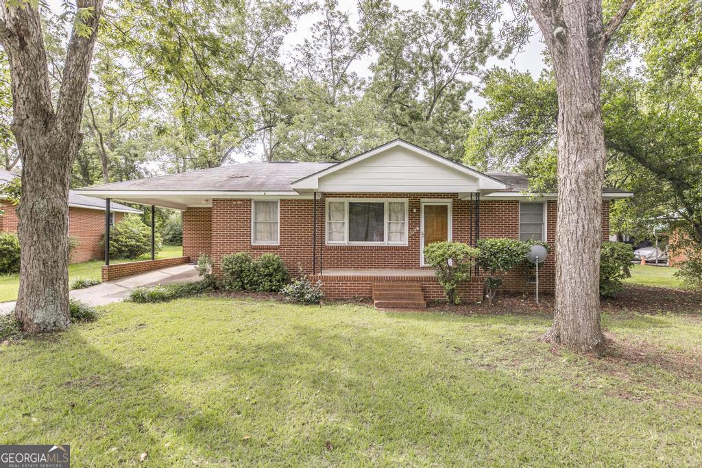 a front view of a house with yard and green space