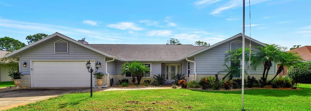 a front view of house with a yard and green space