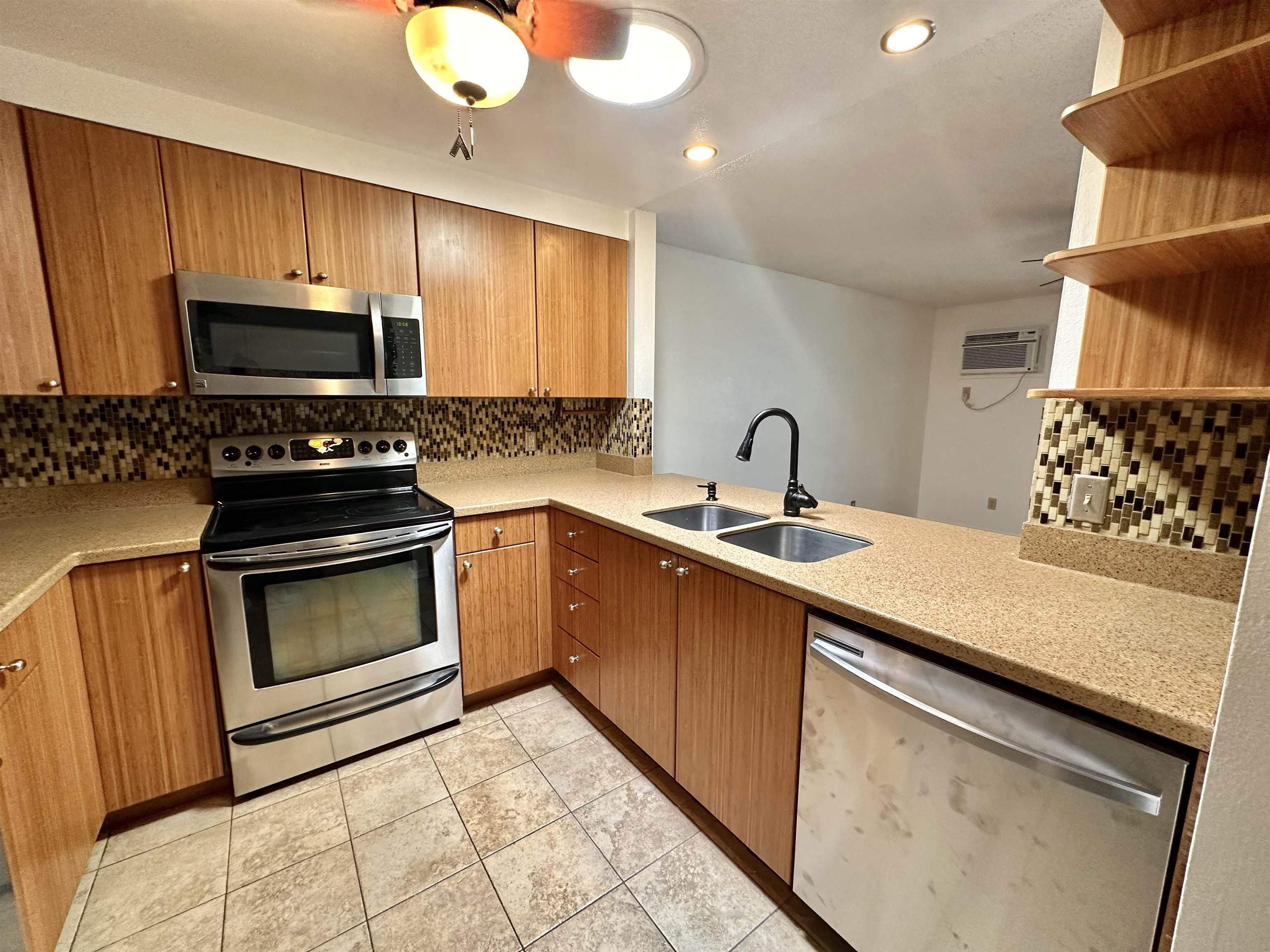 a kitchen with granite countertop a sink cabinets and stainless steel appliances