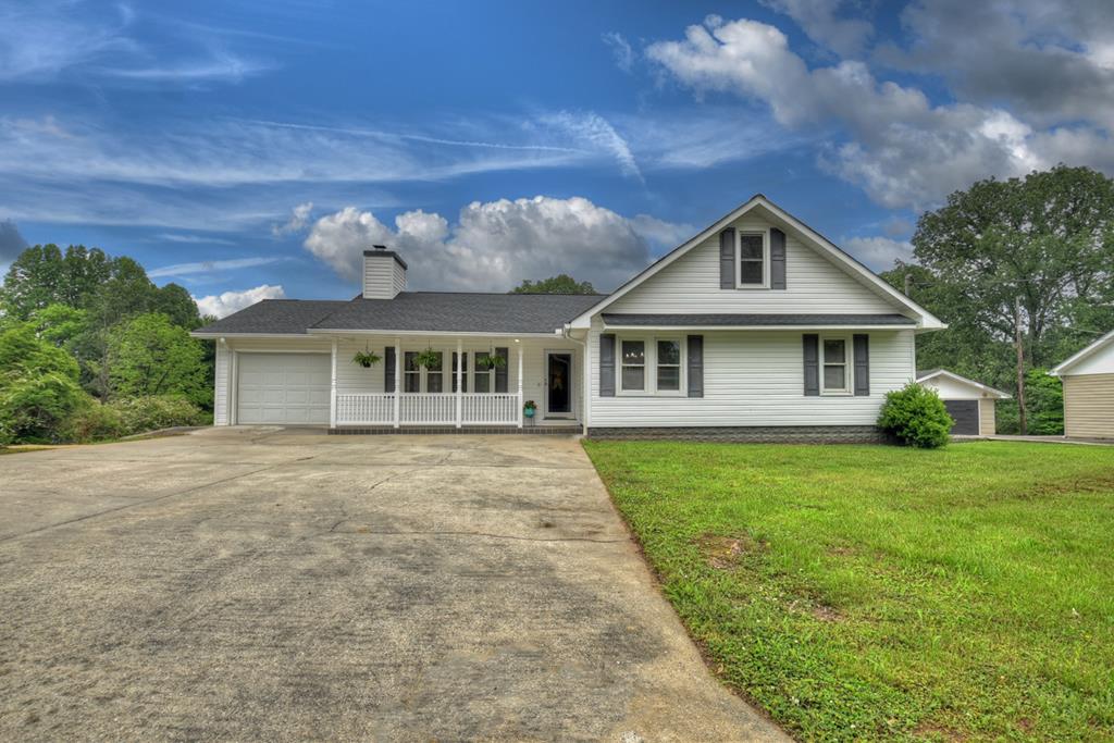 a front view of a house with a garden and yard