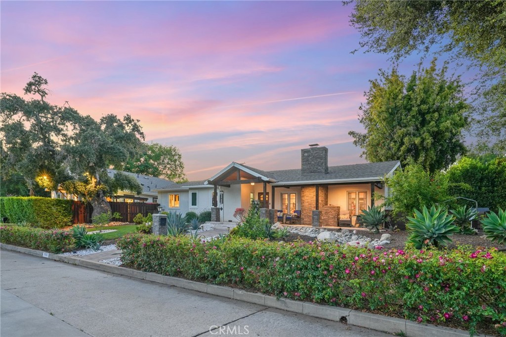 a front view of a house with a yard and potted plants