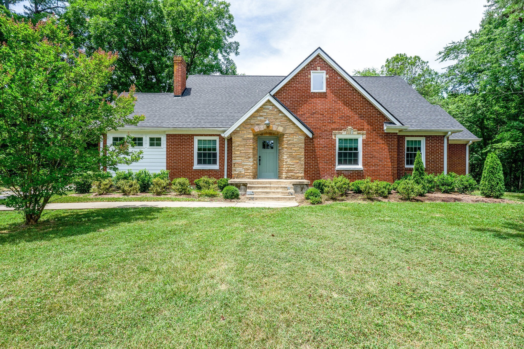 a front view of house with yard and green space