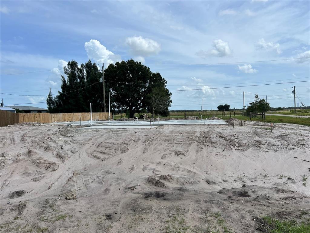 a view of dirt yard with wooden fence