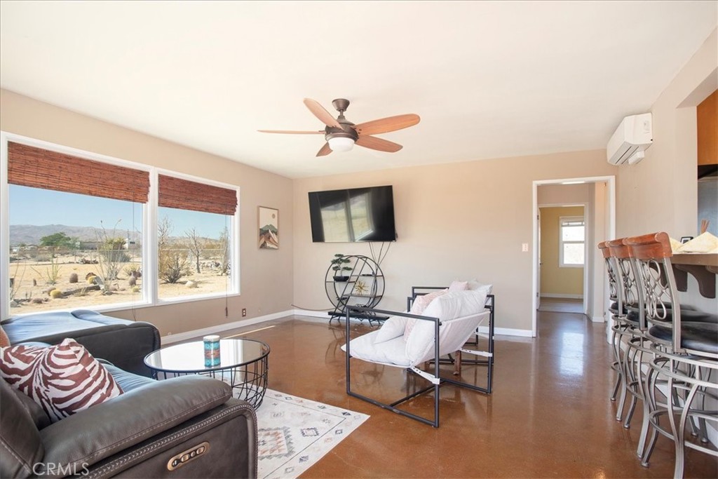 a living room with furniture a flat screen tv and a large window