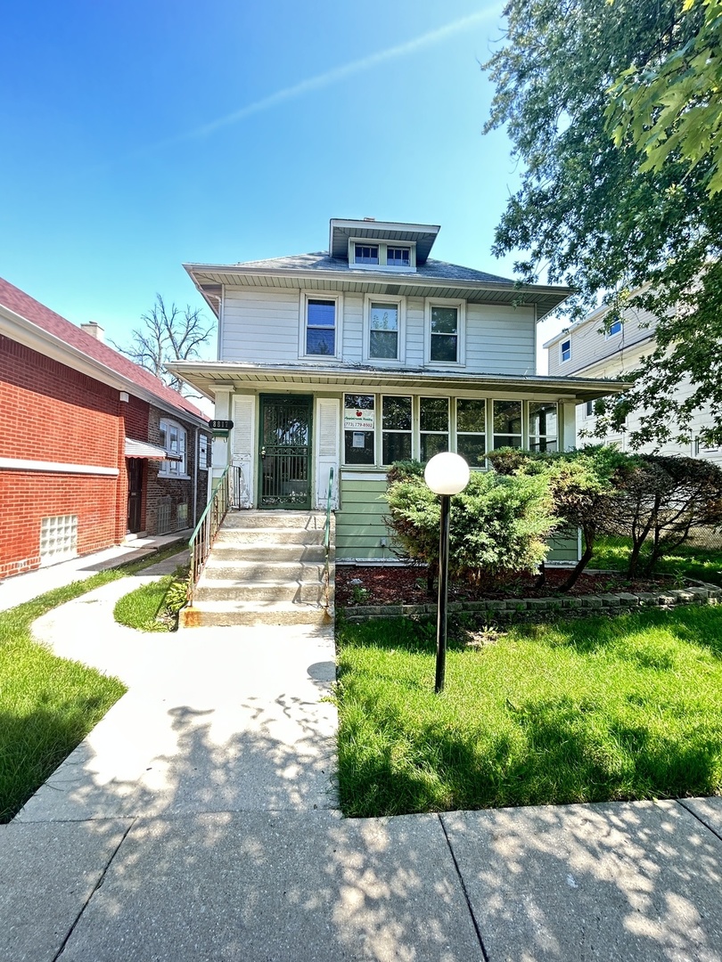 a front view of a house with a yard and green space