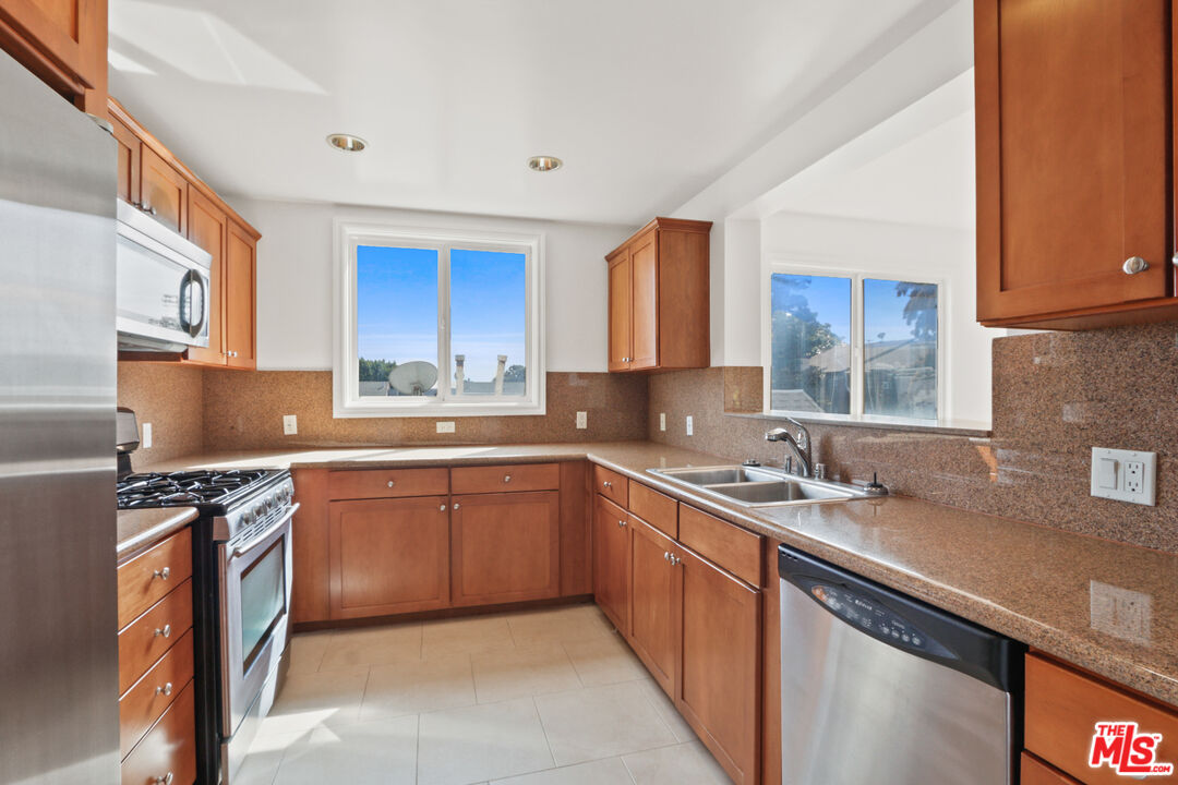 a kitchen with stainless steel appliances granite countertop a sink stove and cabinets