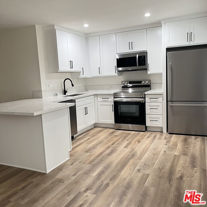 a kitchen with stainless steel appliances a stove sink microwave and refrigerator