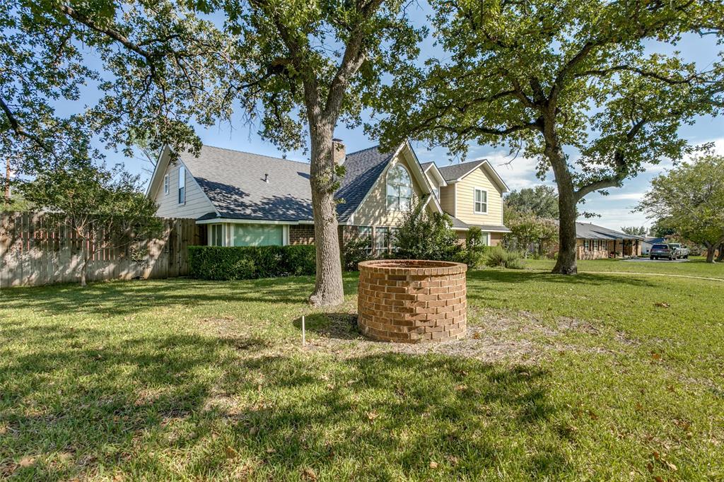 a front view of a house with a yard and tree