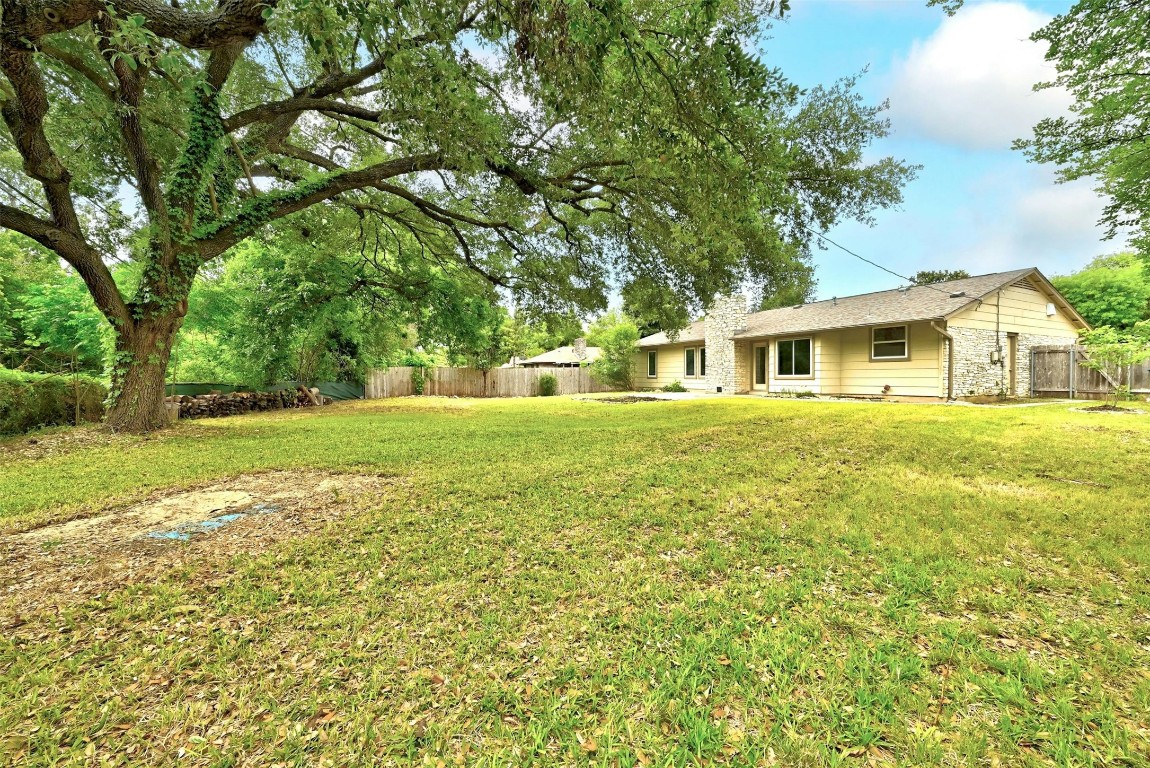 A gorgeous 100-year-old oak tree provides shade and adds to the natural beauty of the backyard landscape.