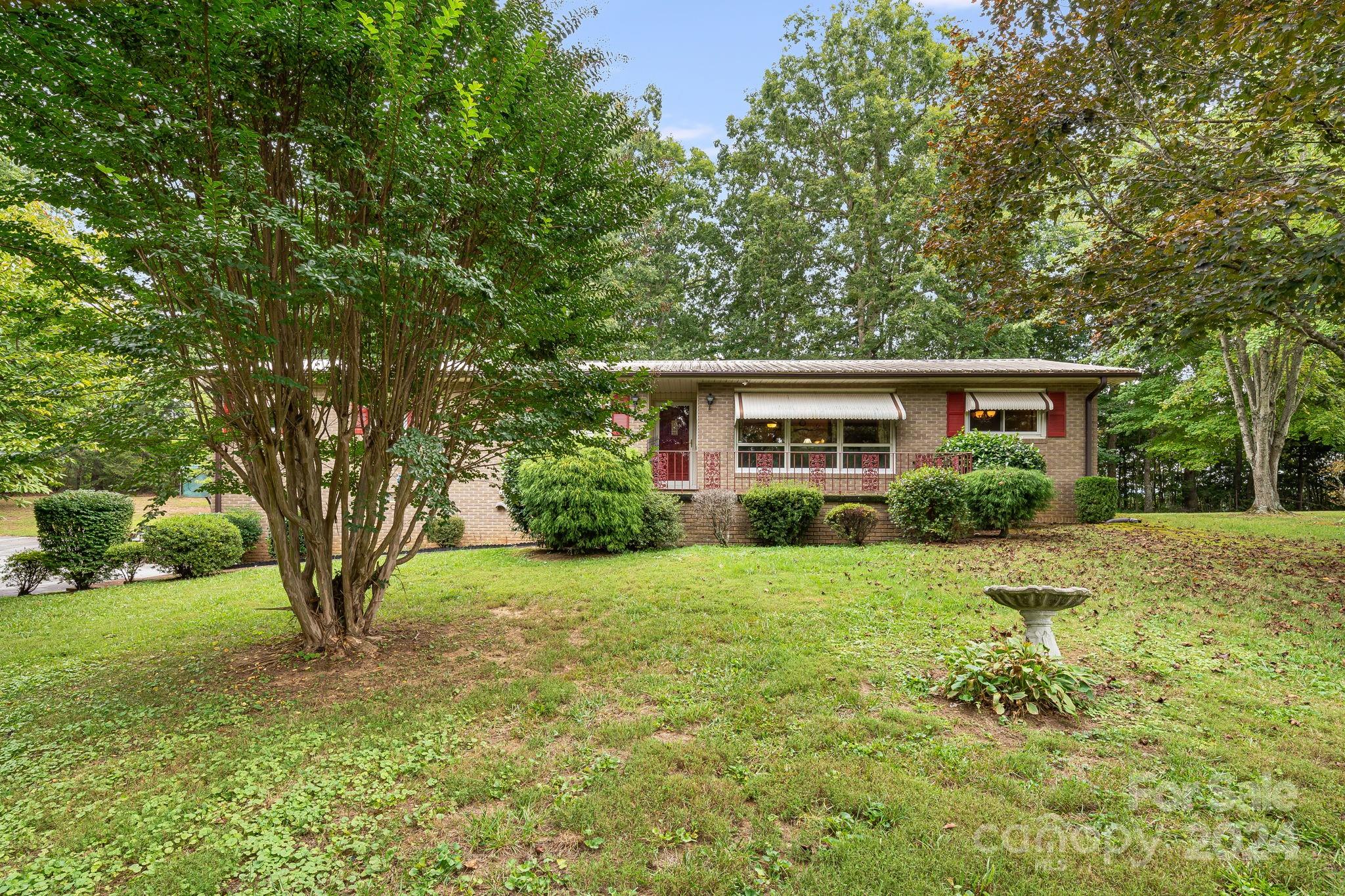 a view of a house with backyard and a tree