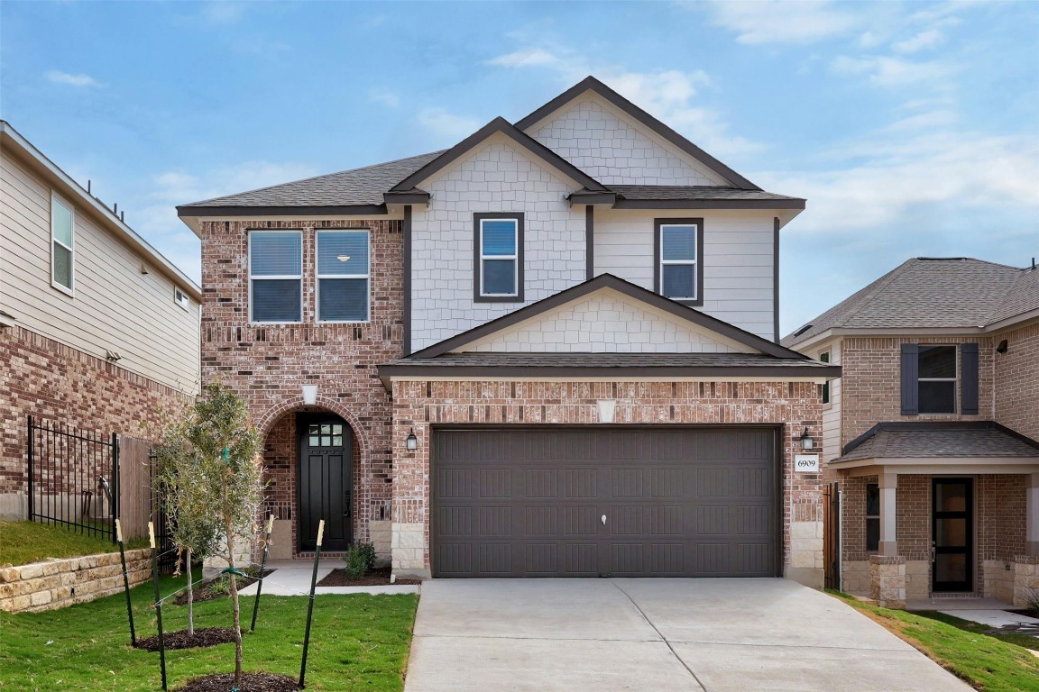 a front view of a house with a yard and garage