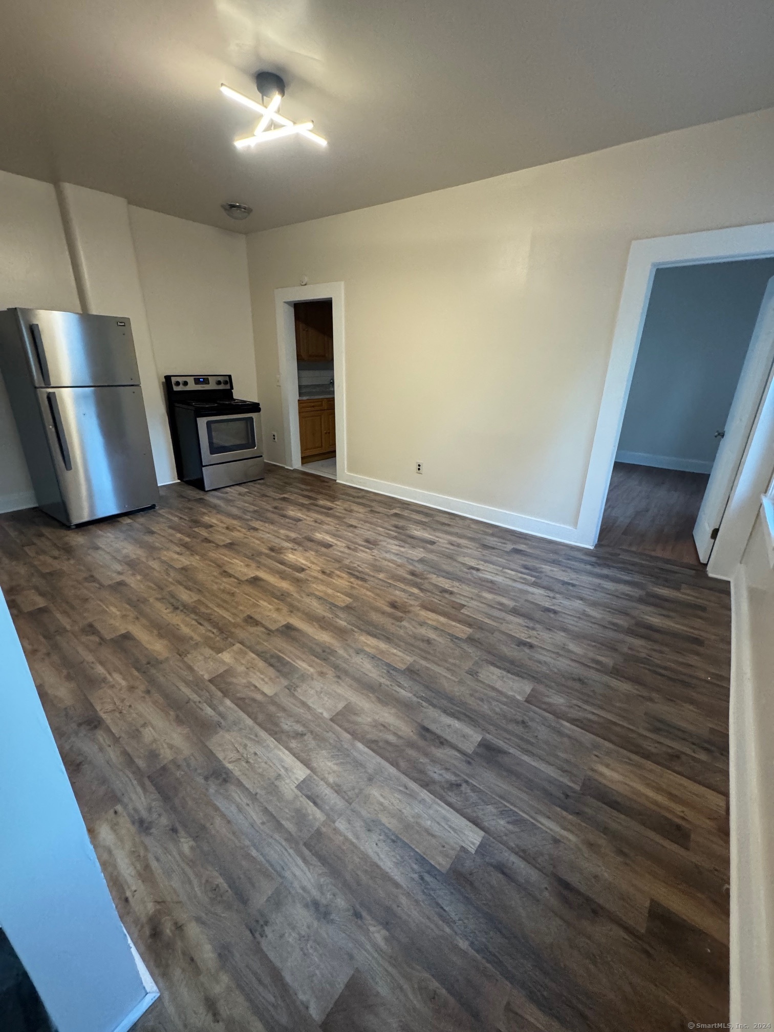 a view of empty room with wooden floor