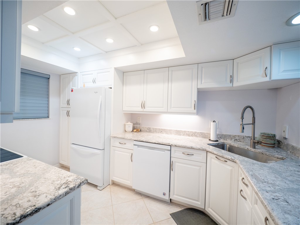 a kitchen with a sink dishwasher a stove a refrigerator and cabinets