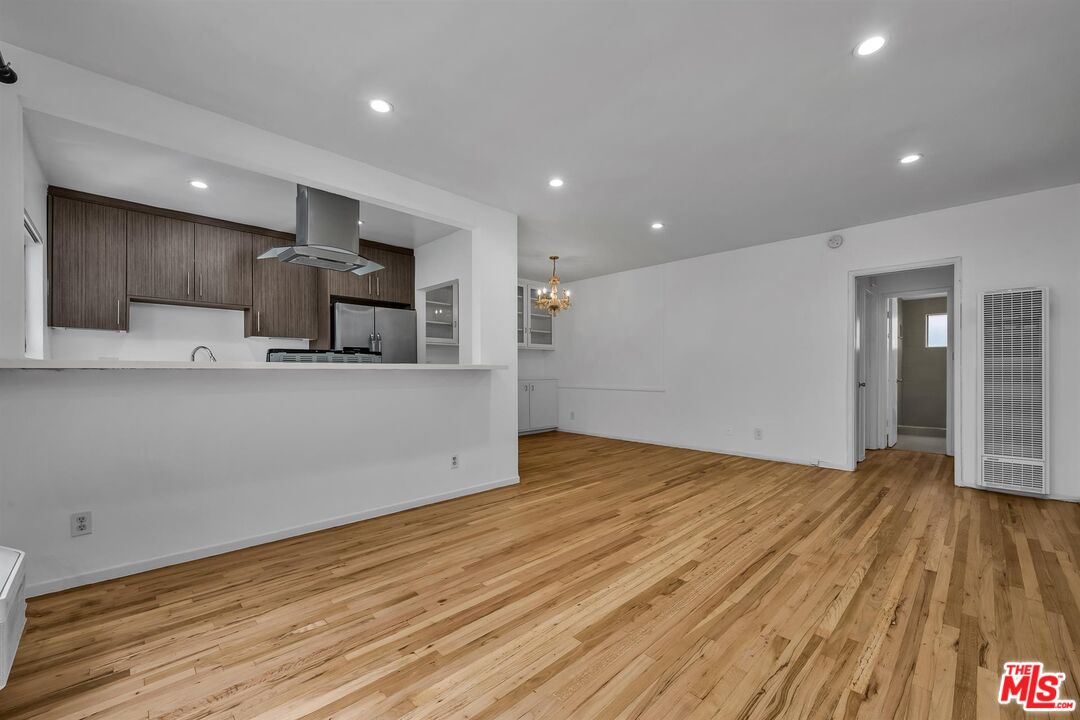 a view of kitchen with wooden floor and electronic appliances