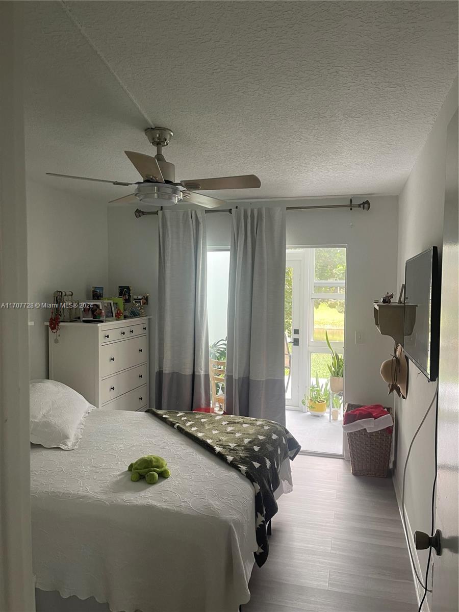 a bedroom with a bed and a flat tv screen on the dresser