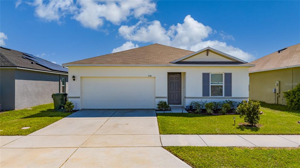 a front view of a house with a yard and garage