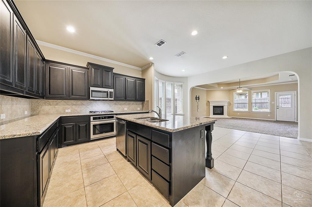 a kitchen with stainless steel appliances granite countertop a stove sink and cabinets