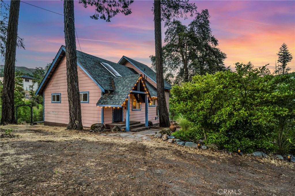 a view of a house with a yard and tree