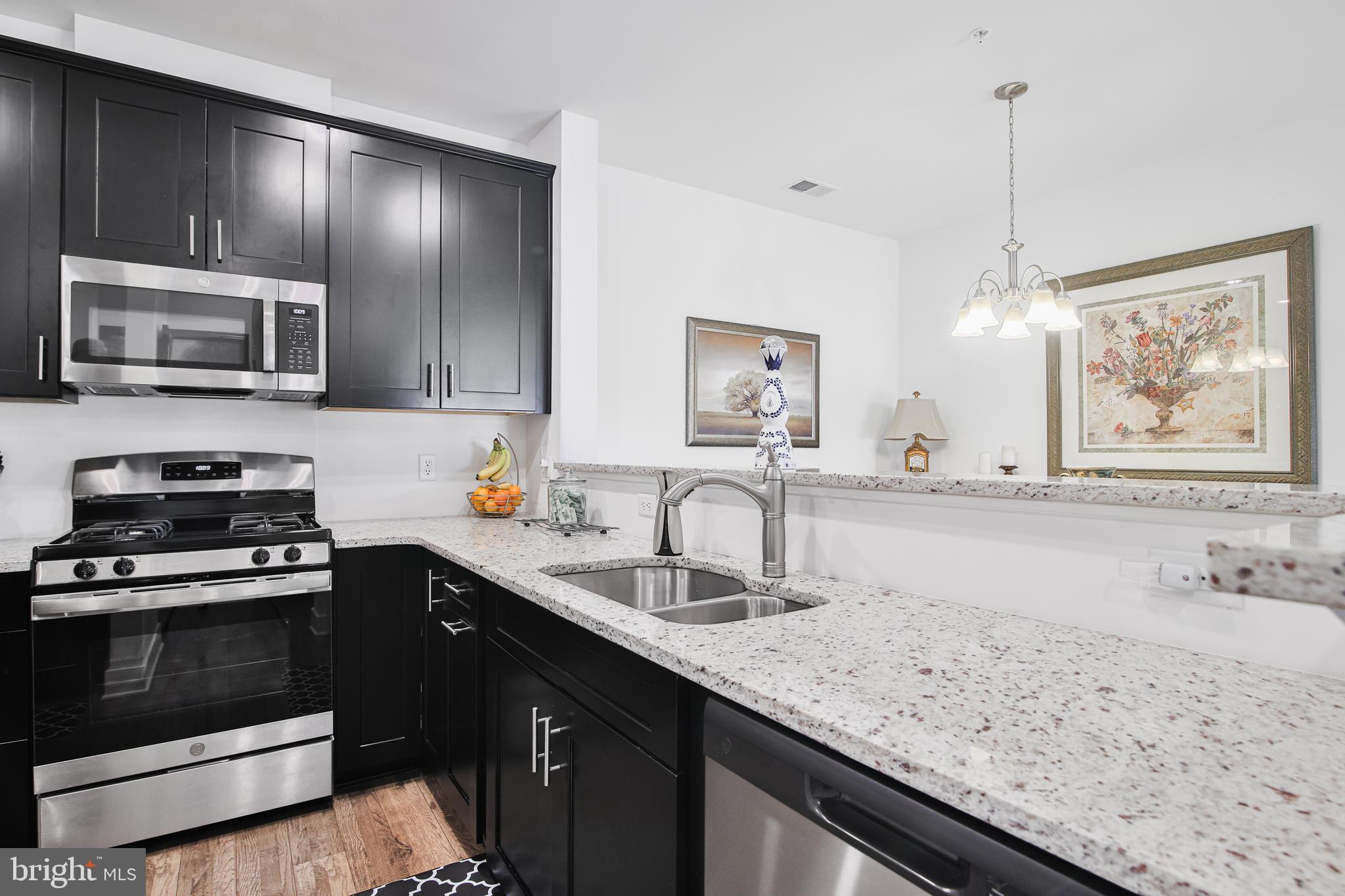 a kitchen with stainless steel appliances granite countertop a sink stove and microwave