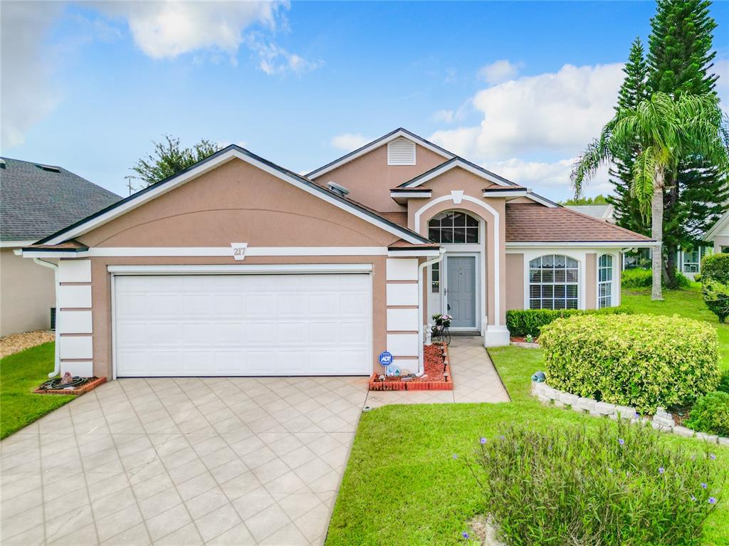 a front view of a house with a yard and garage