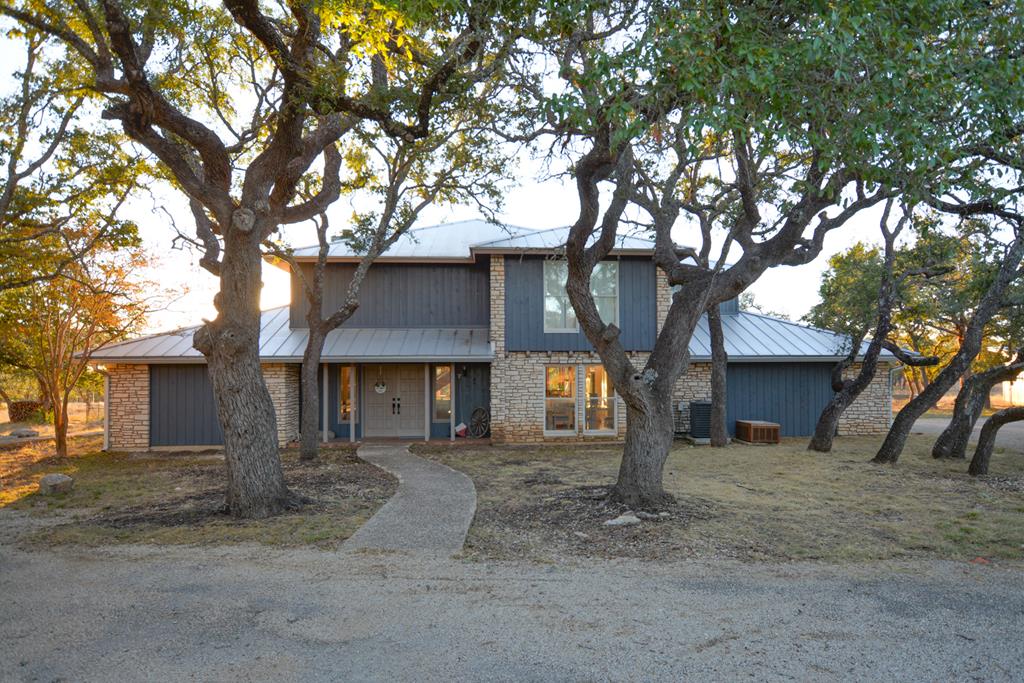 a front view of a house with a tree