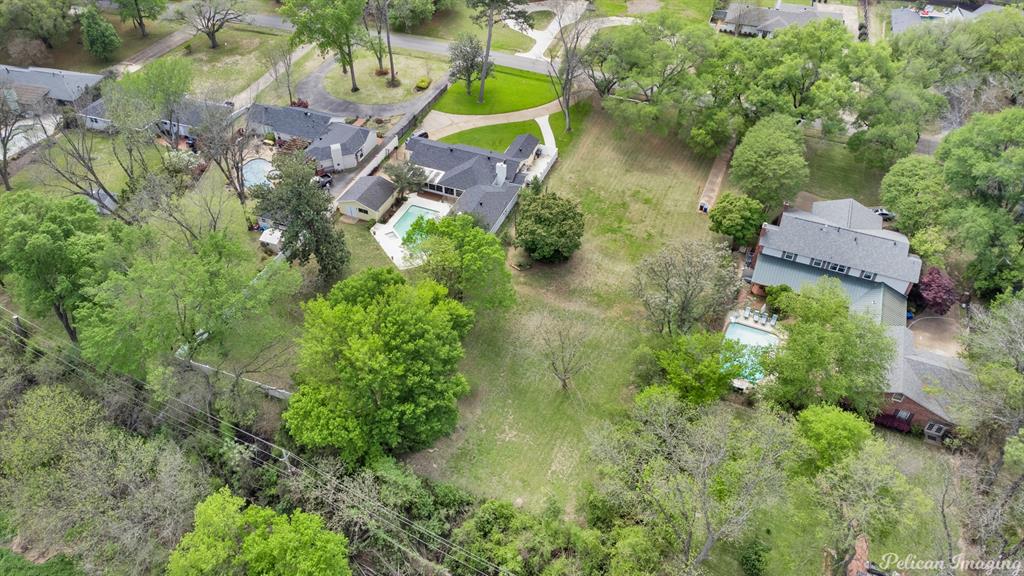 an aerial view of residential house with outdoor space and trees all around