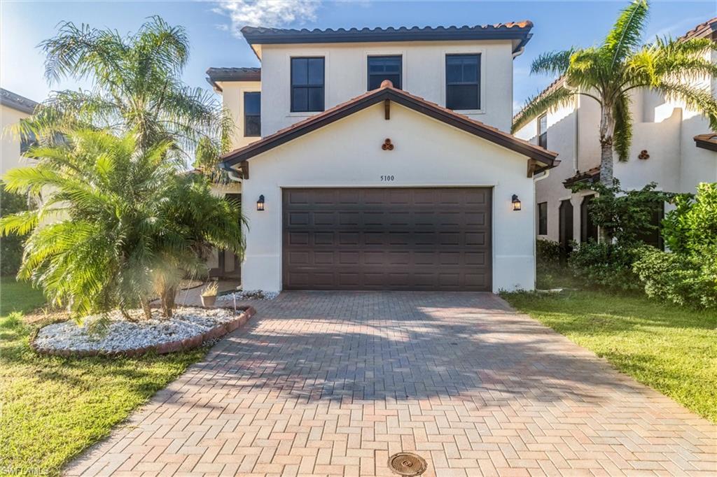 Mediterranean / spanish home featuring a garage and a front lawn