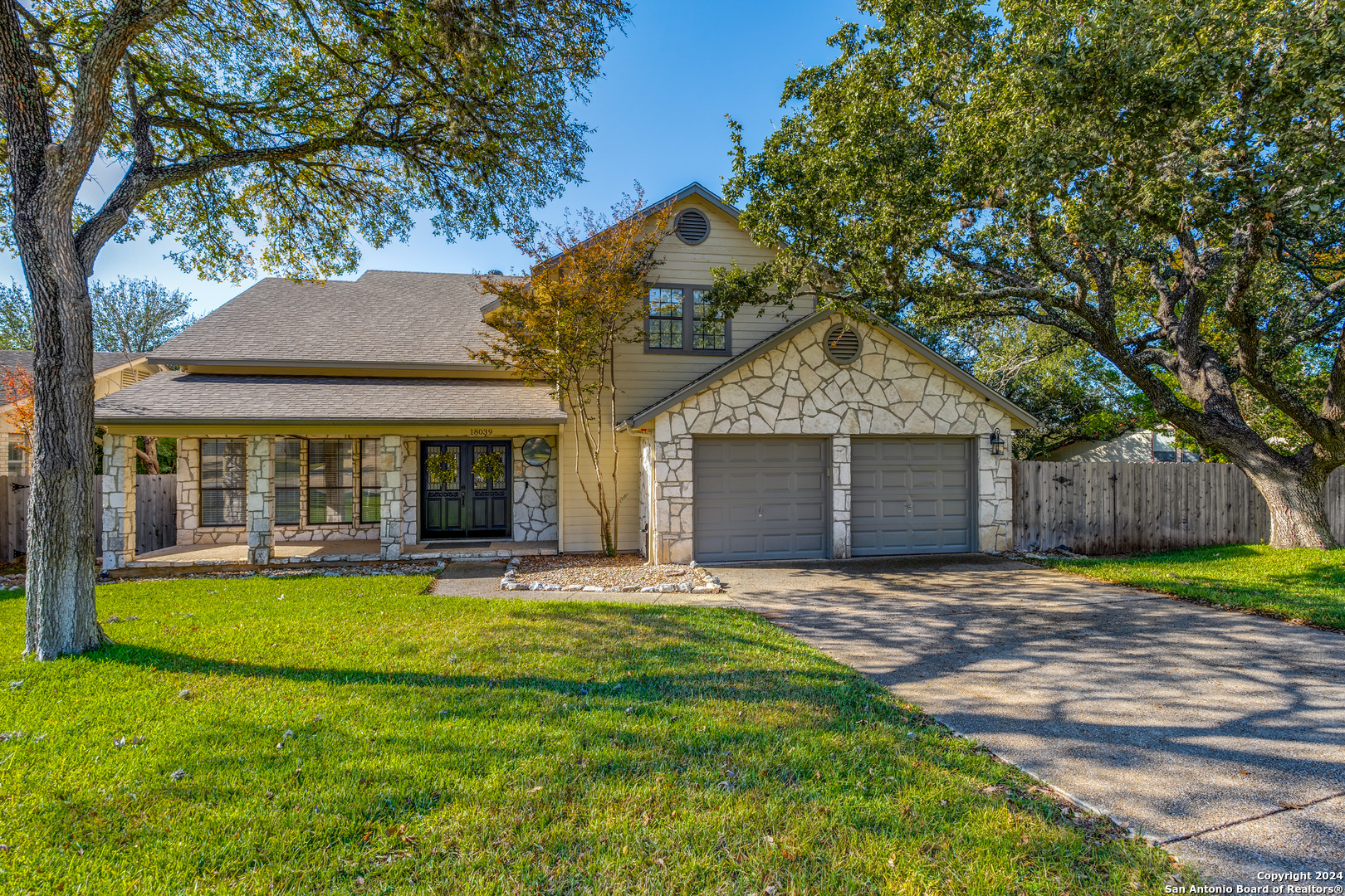 a front view of a house with a yard and trees