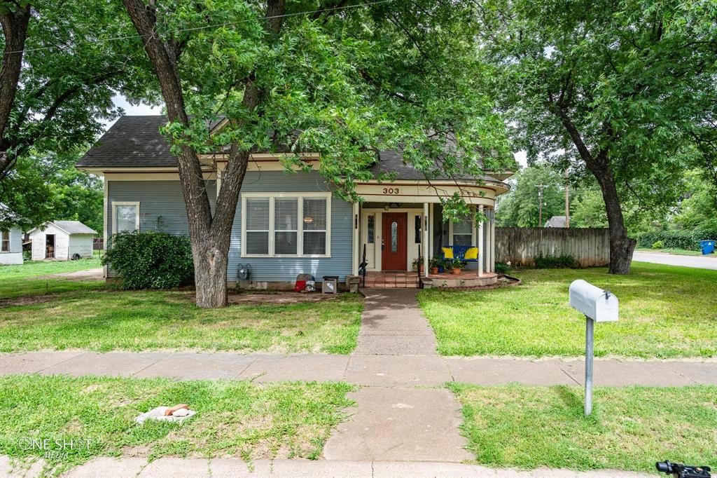 View of front of house featuring a front lawn and covered porch