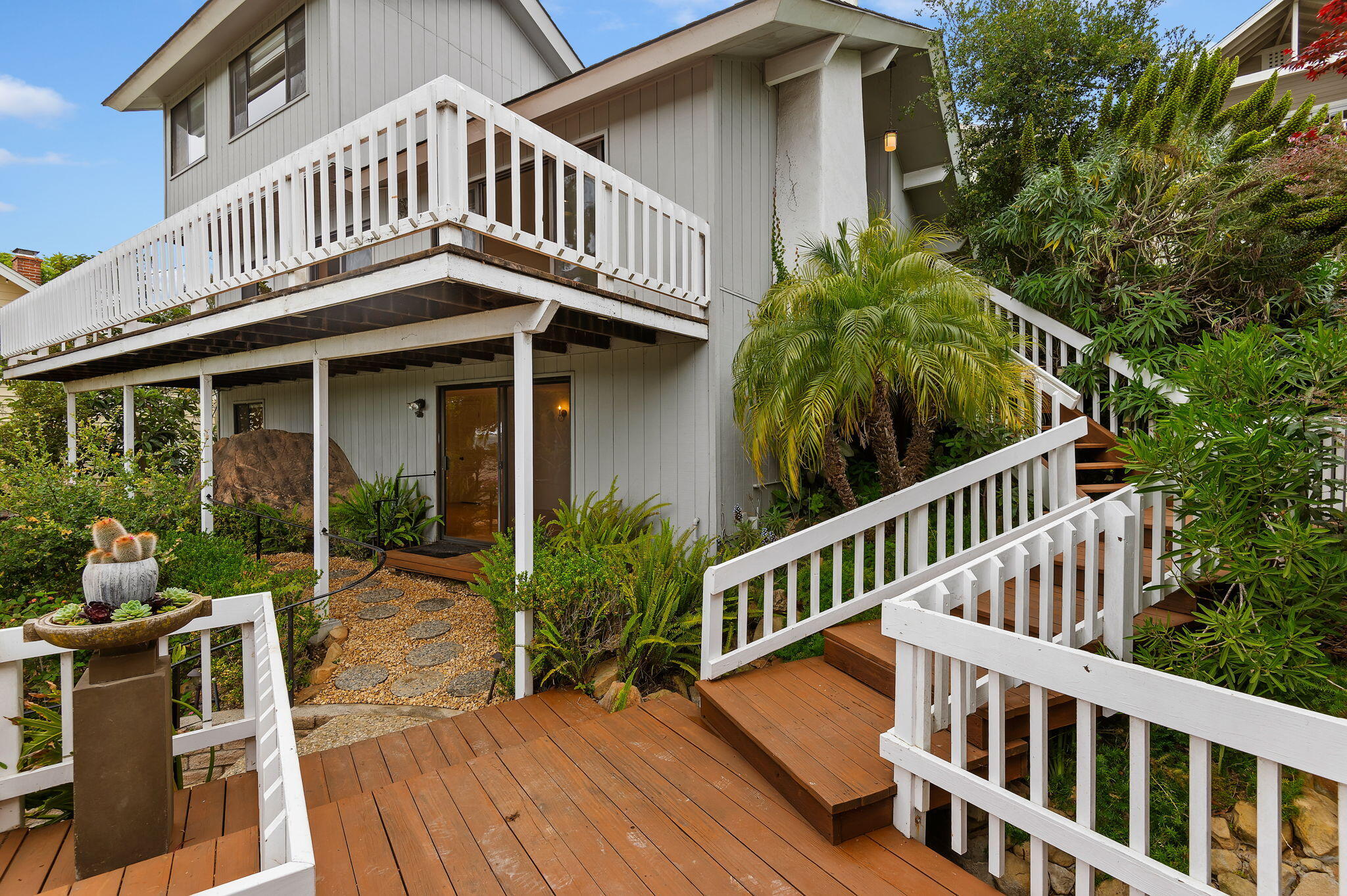 a view of a house with a deck and furniture