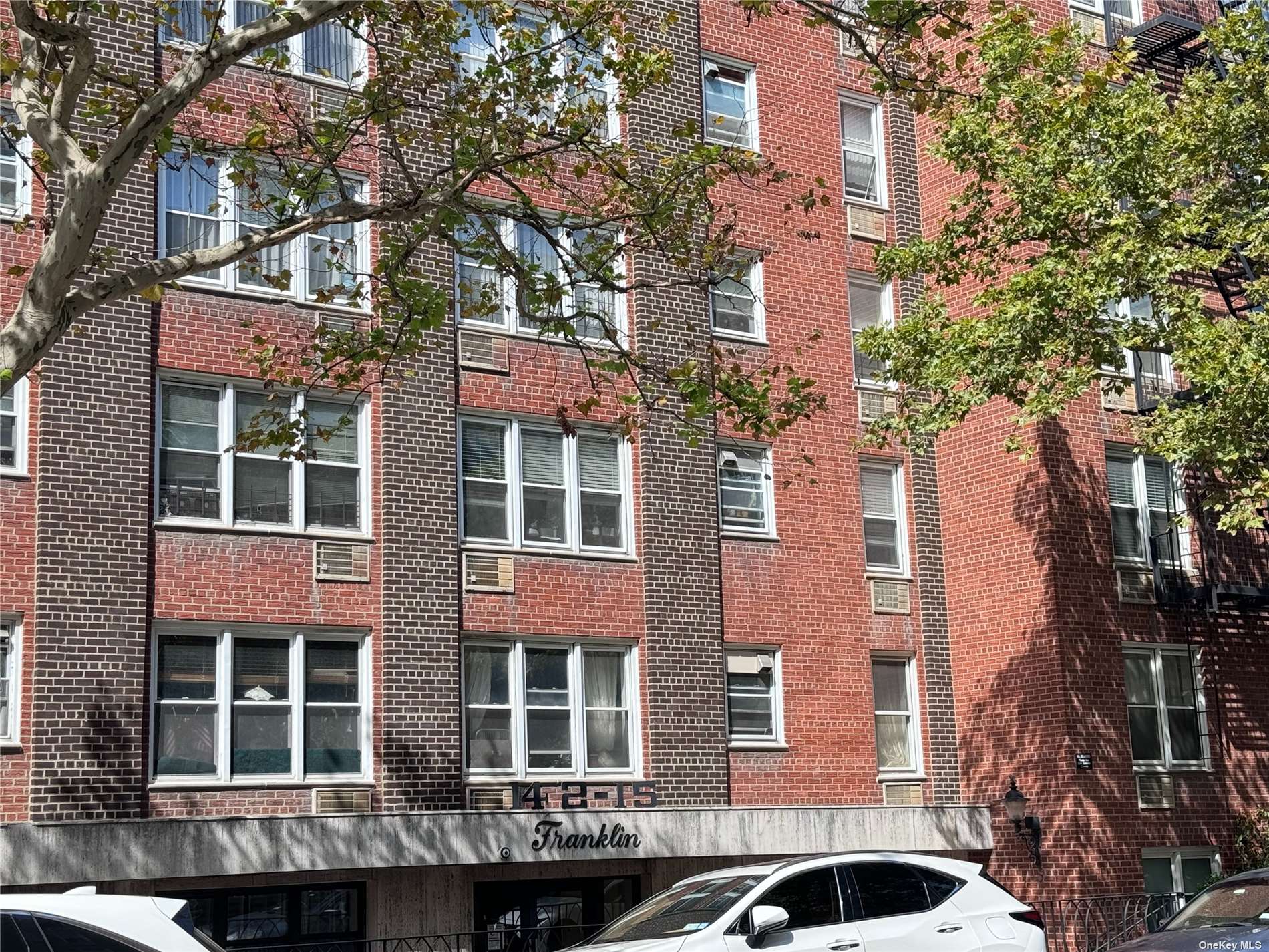 a front view of a building with a tree