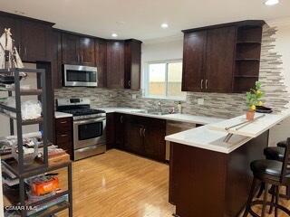 a kitchen with stainless steel appliances kitchen island granite countertop a sink stove and refrigerator