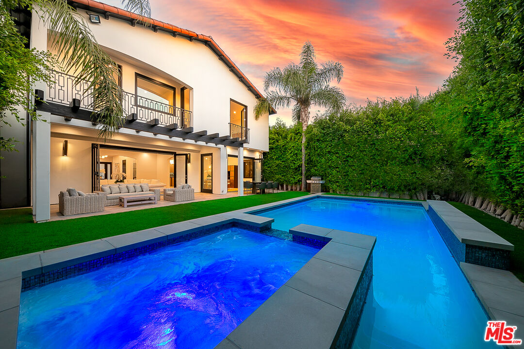 a view of swimming pool with lawn chairs and plants