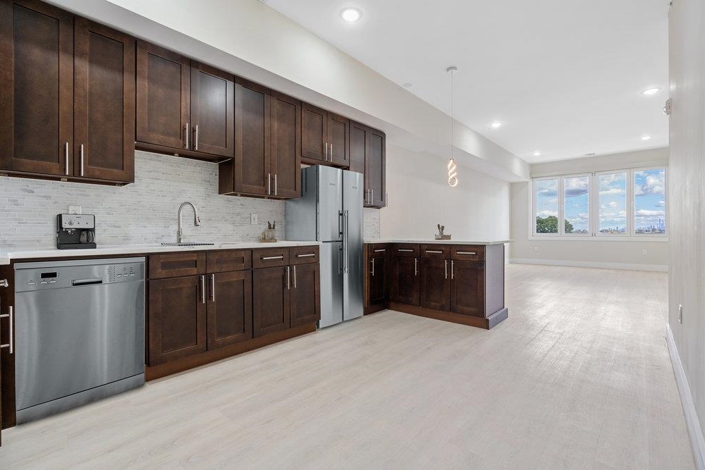 a kitchen with stainless steel appliances granite countertop a sink stove and cabinets