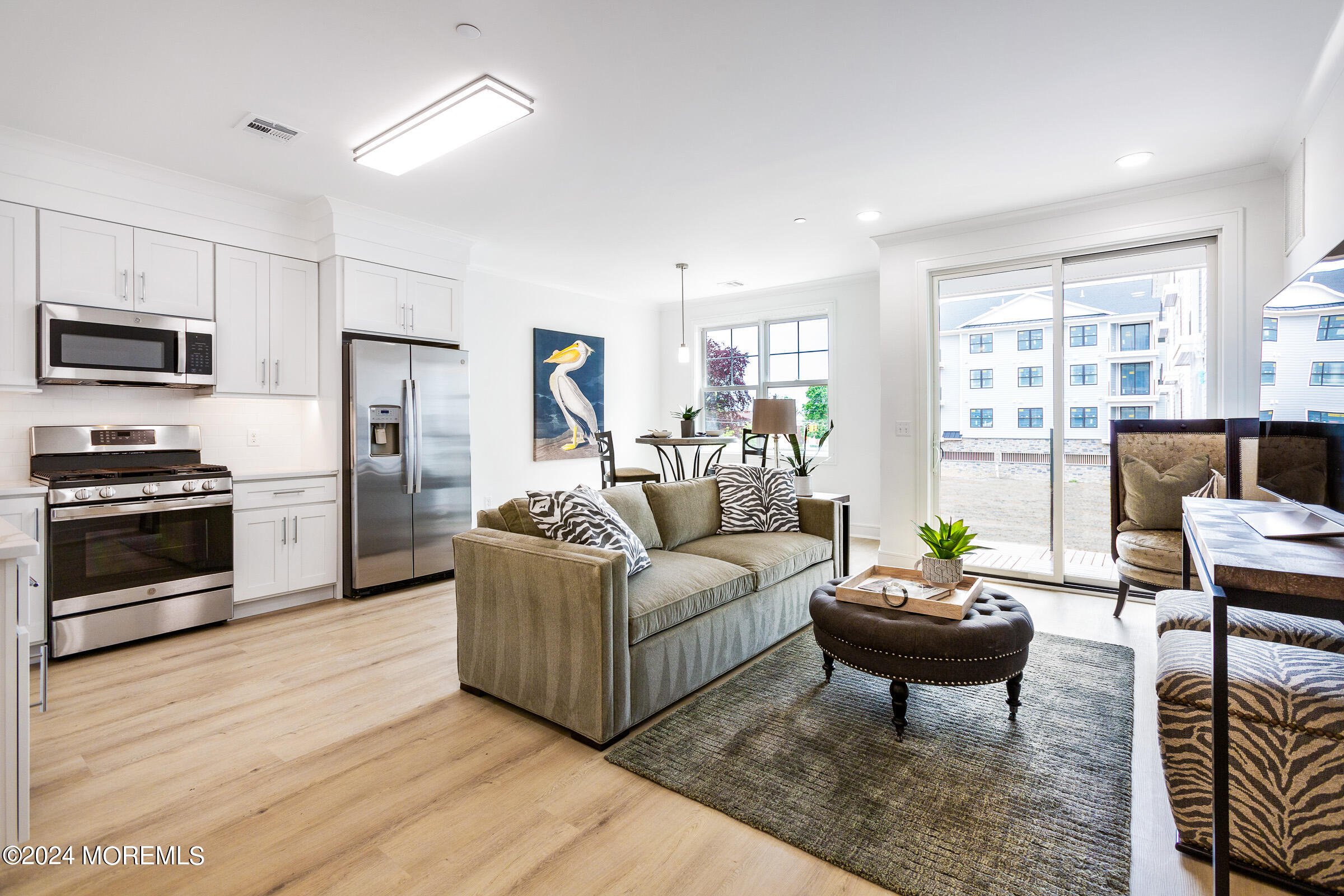 a living room with furniture a flat screen tv and a large window