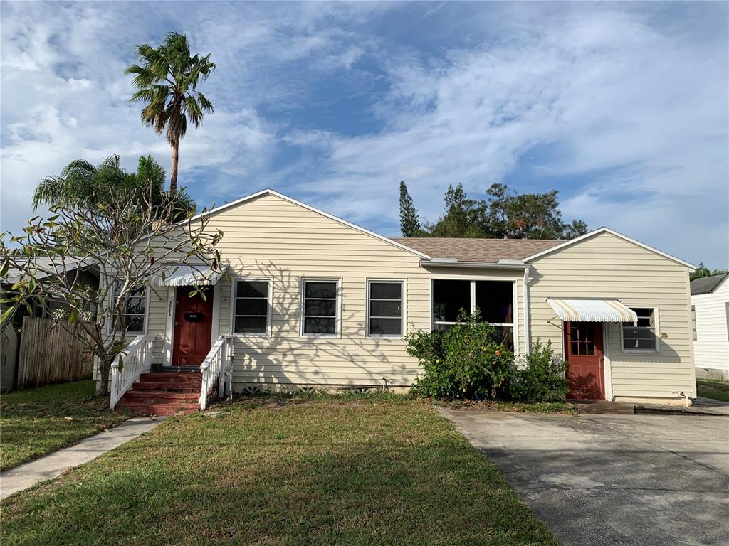 a front view of a house with a yard and potted plants