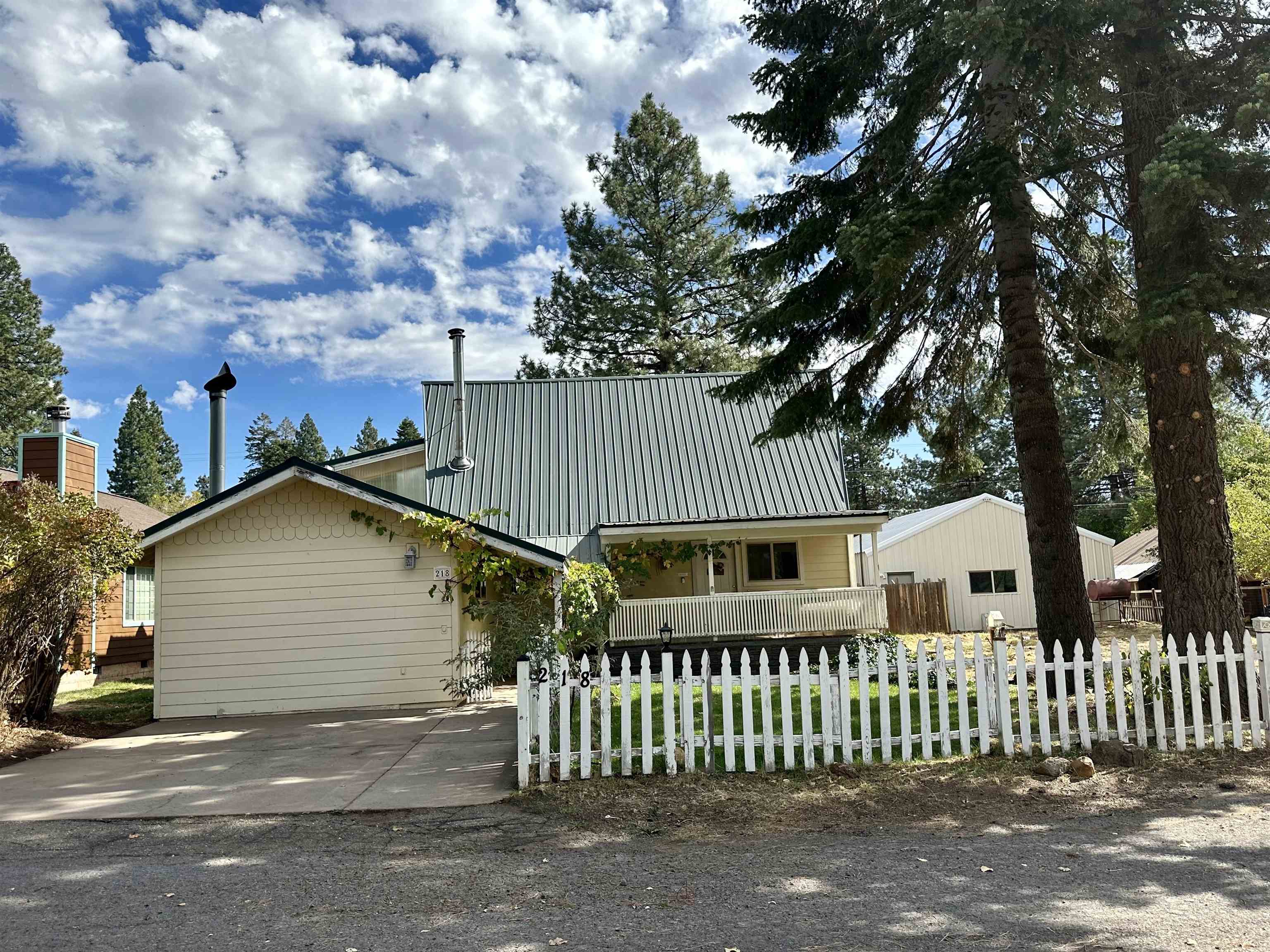 a view of a house with a small yard and wooden fence