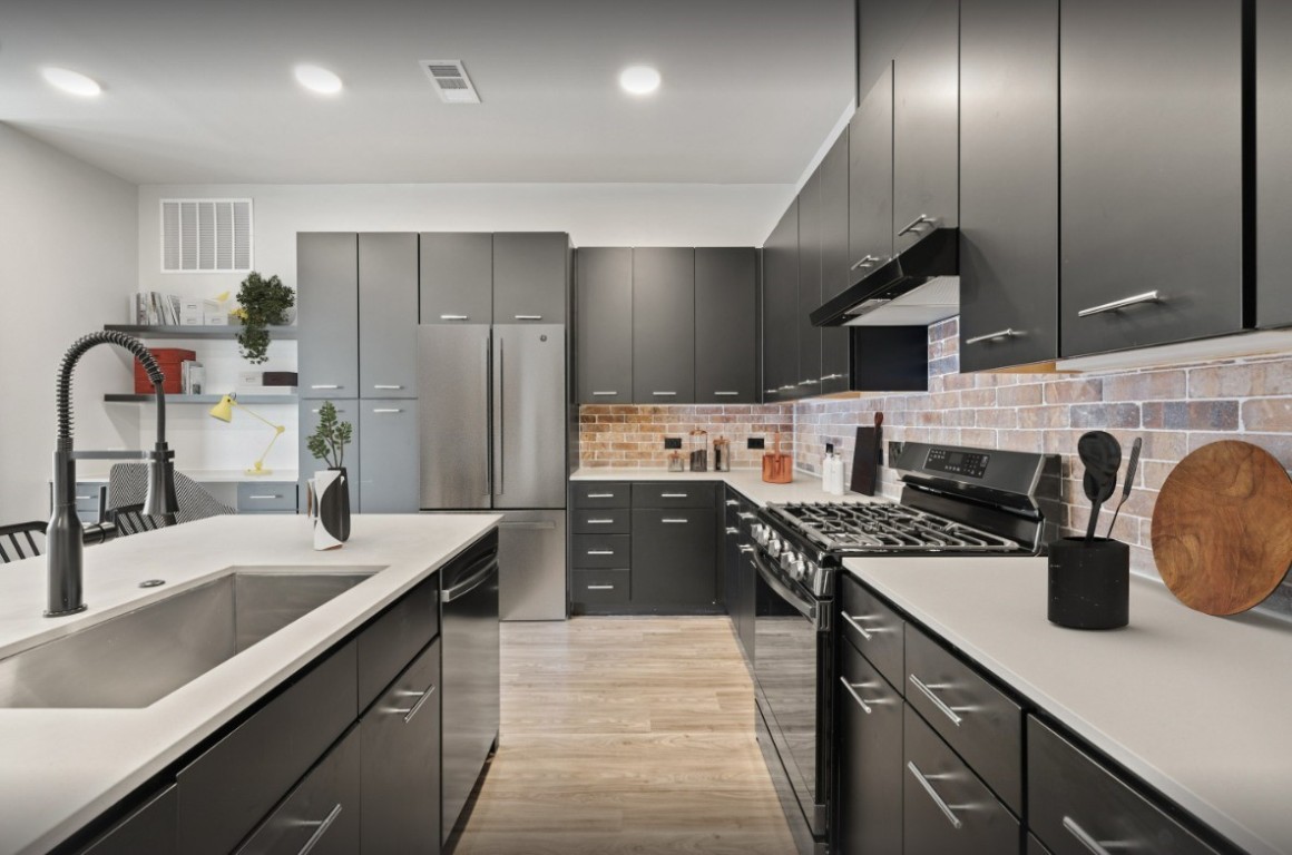 a kitchen with stainless steel appliances a sink stove and refrigerator