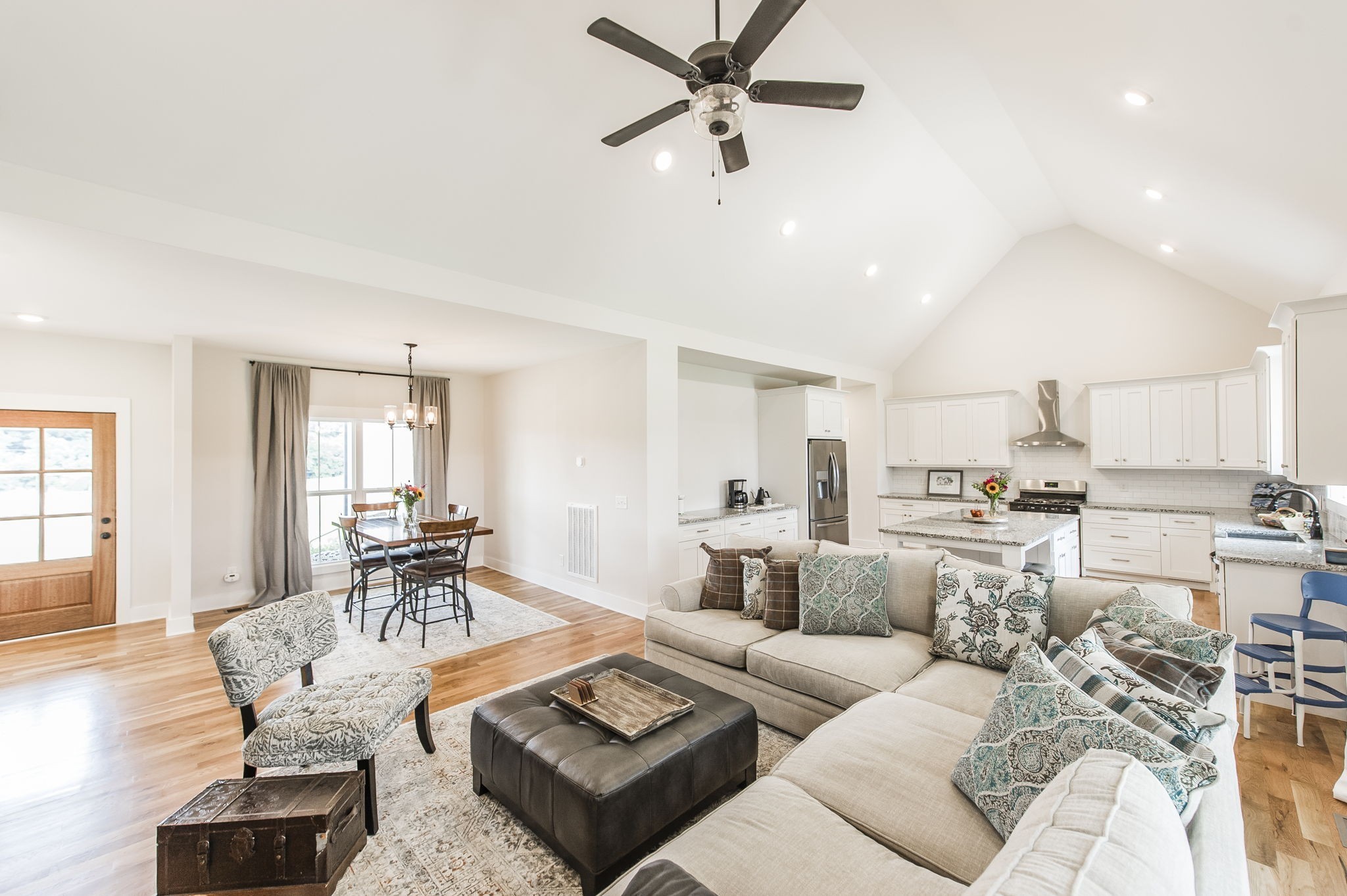 a living room with furniture kitchen view and a window