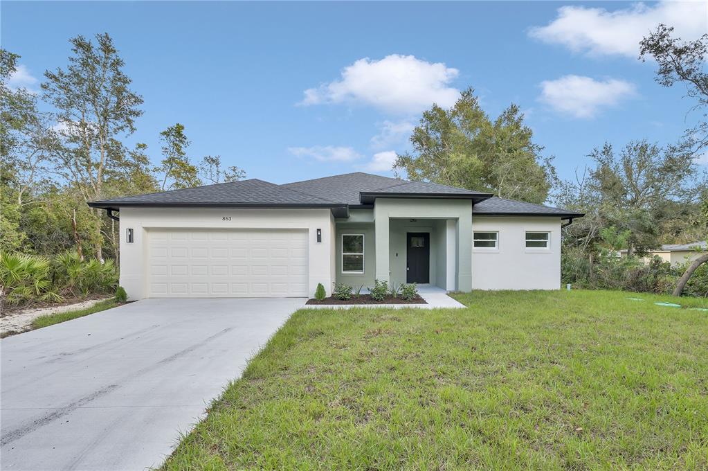 a front view of a house with a yard and garage