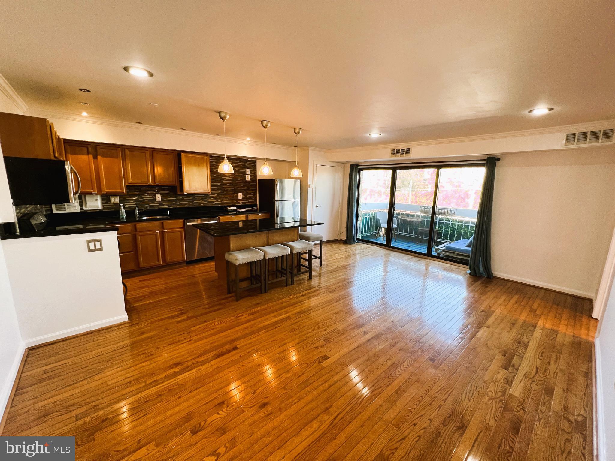 a open kitchen with stainless steel appliances granite countertop a stove and a wooden floors