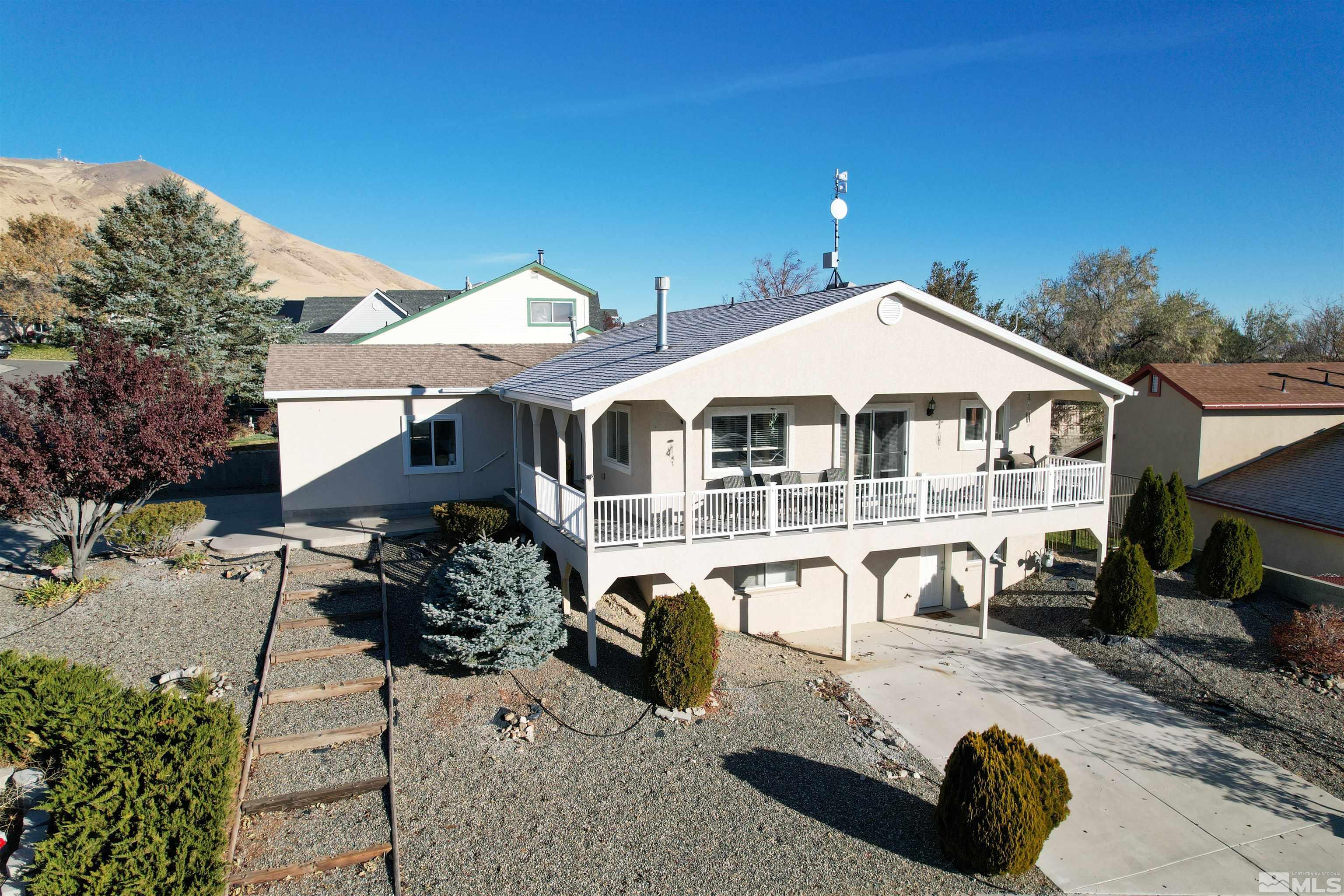 a view of a white house with a yard porch and furniture