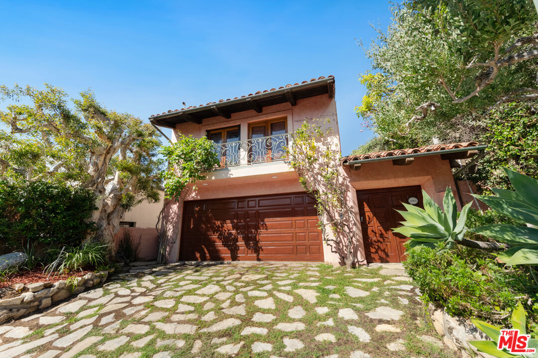 a front view of a house with a tree