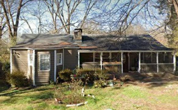 front view of house with a yard and potted plants