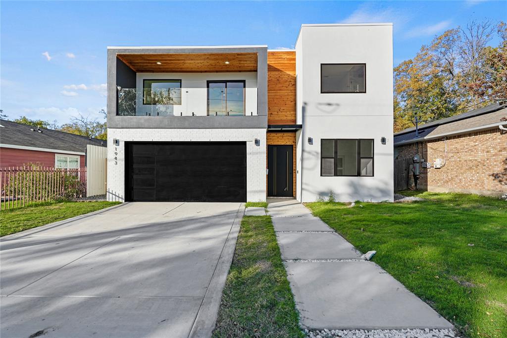 Modern home featuring a garage and a front lawn