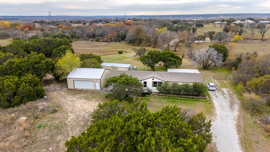 an aerial view of a house with a garden and lake view