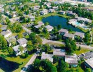 an aerial view of residential houses with outdoor space and trees all around