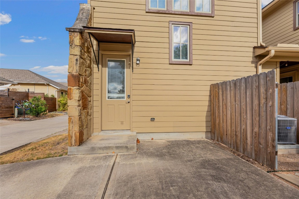 a view of a house with a door and wooden bench